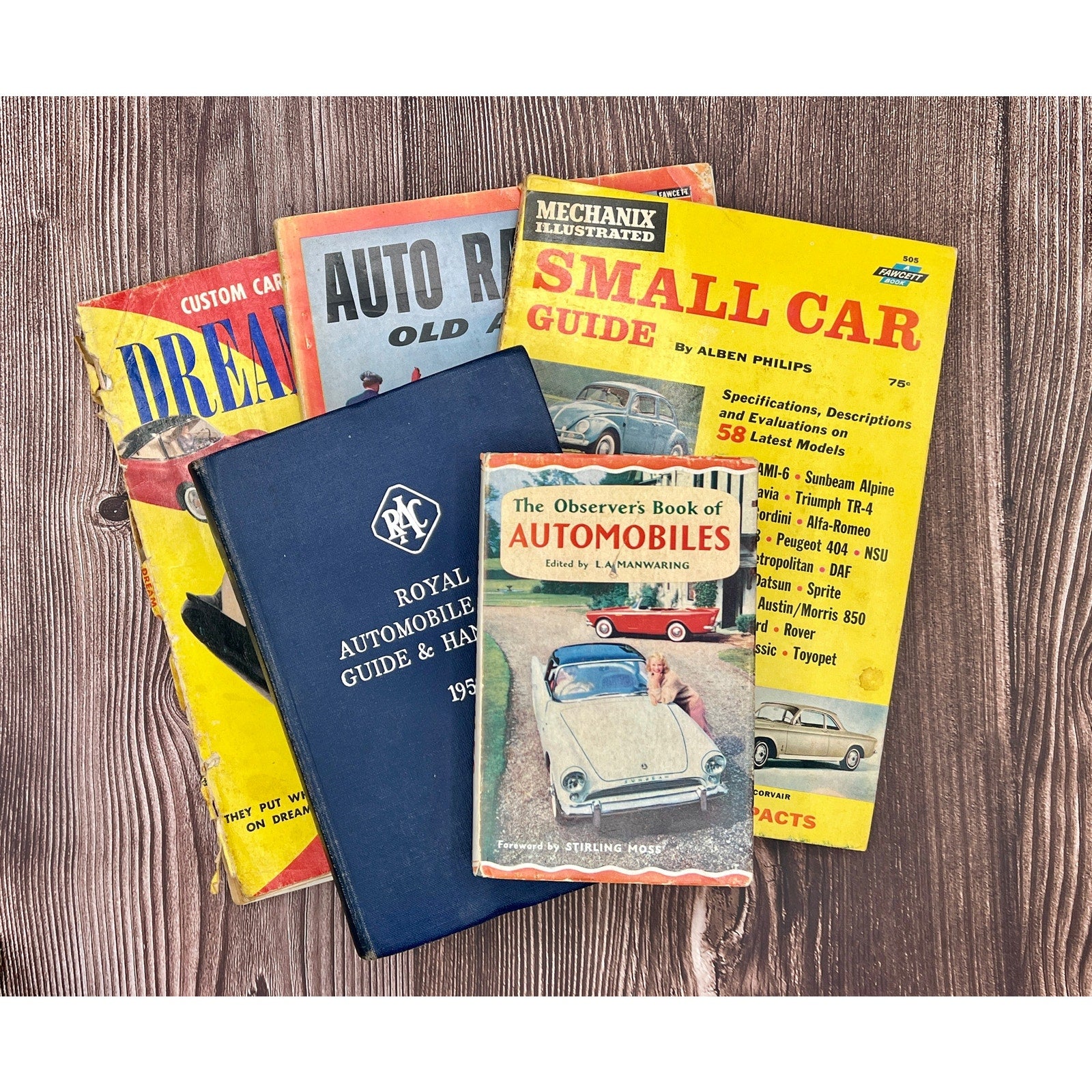 Collection of vintage car books on a wooden surface