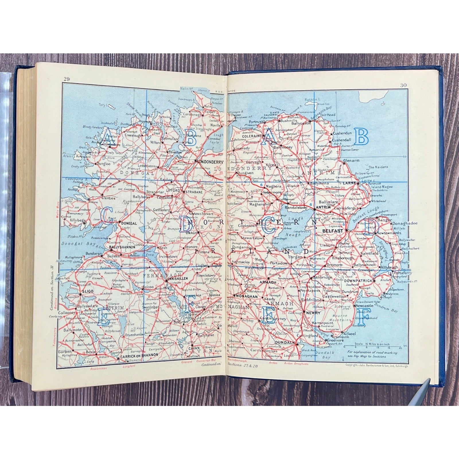 Open book displaying a map of Ireland on a wooden surface